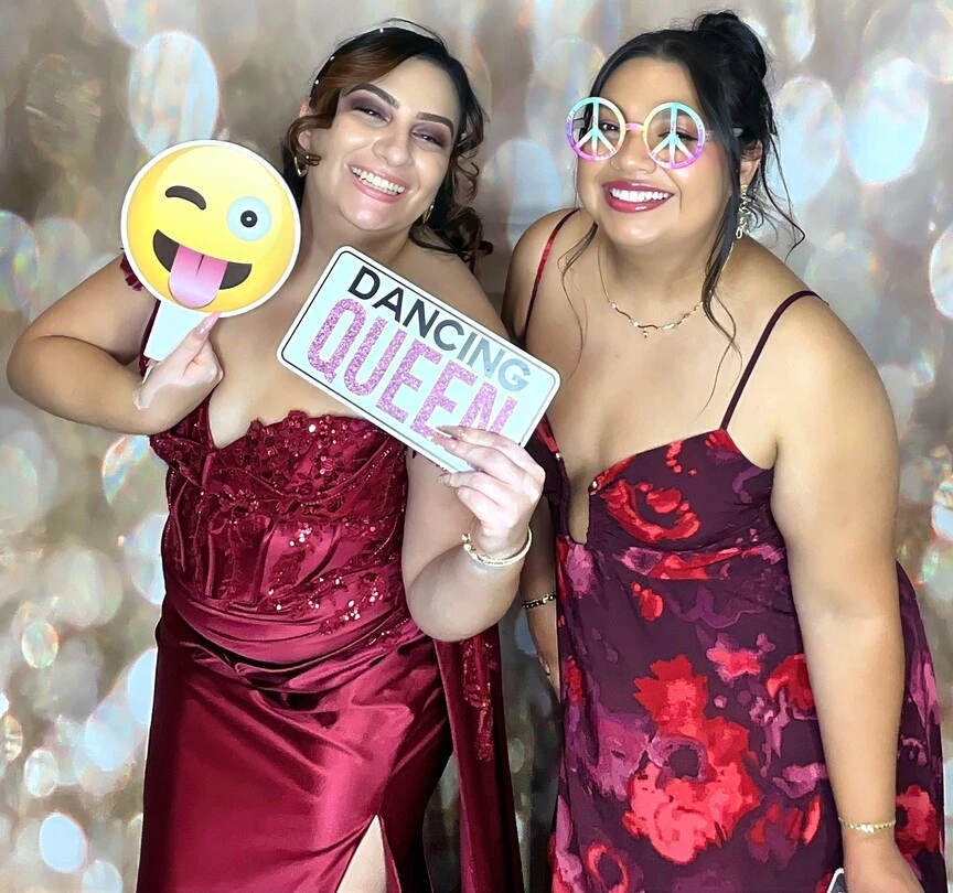 Friends pose with playful photo booth props at a Los Angeles celebration.