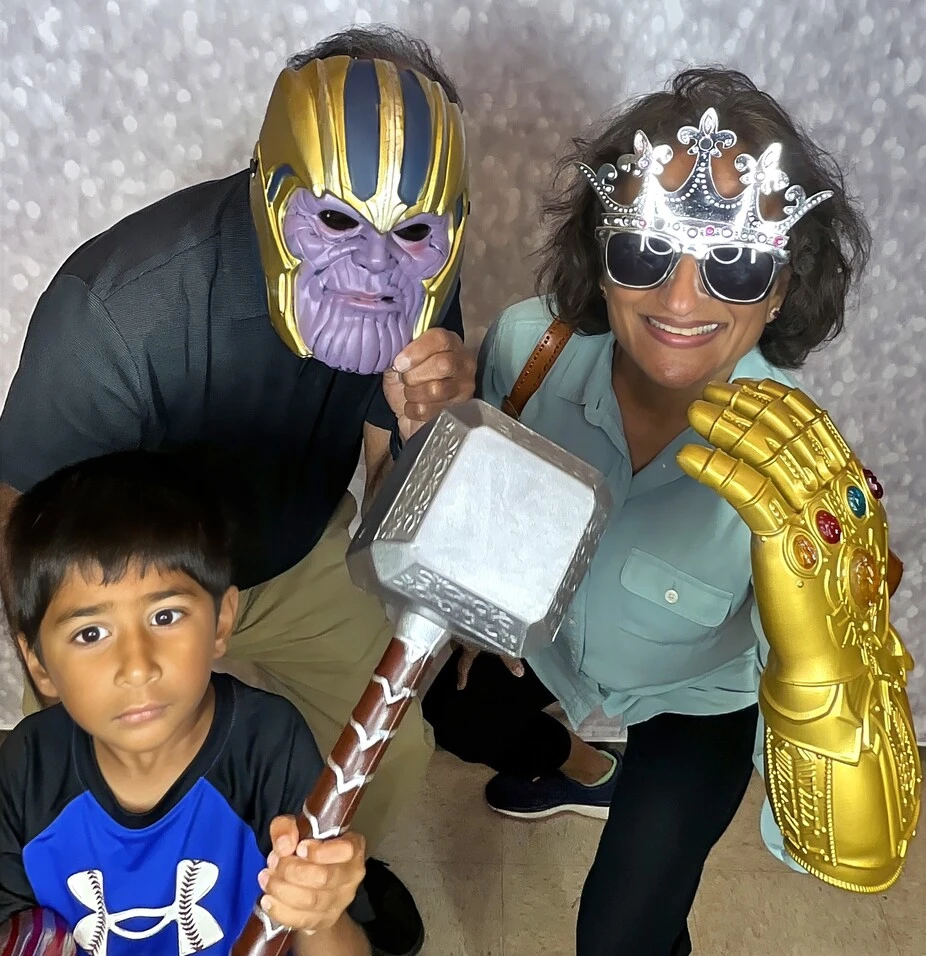 A family poses with playful photo booth props at a fiesta-themed celebration.