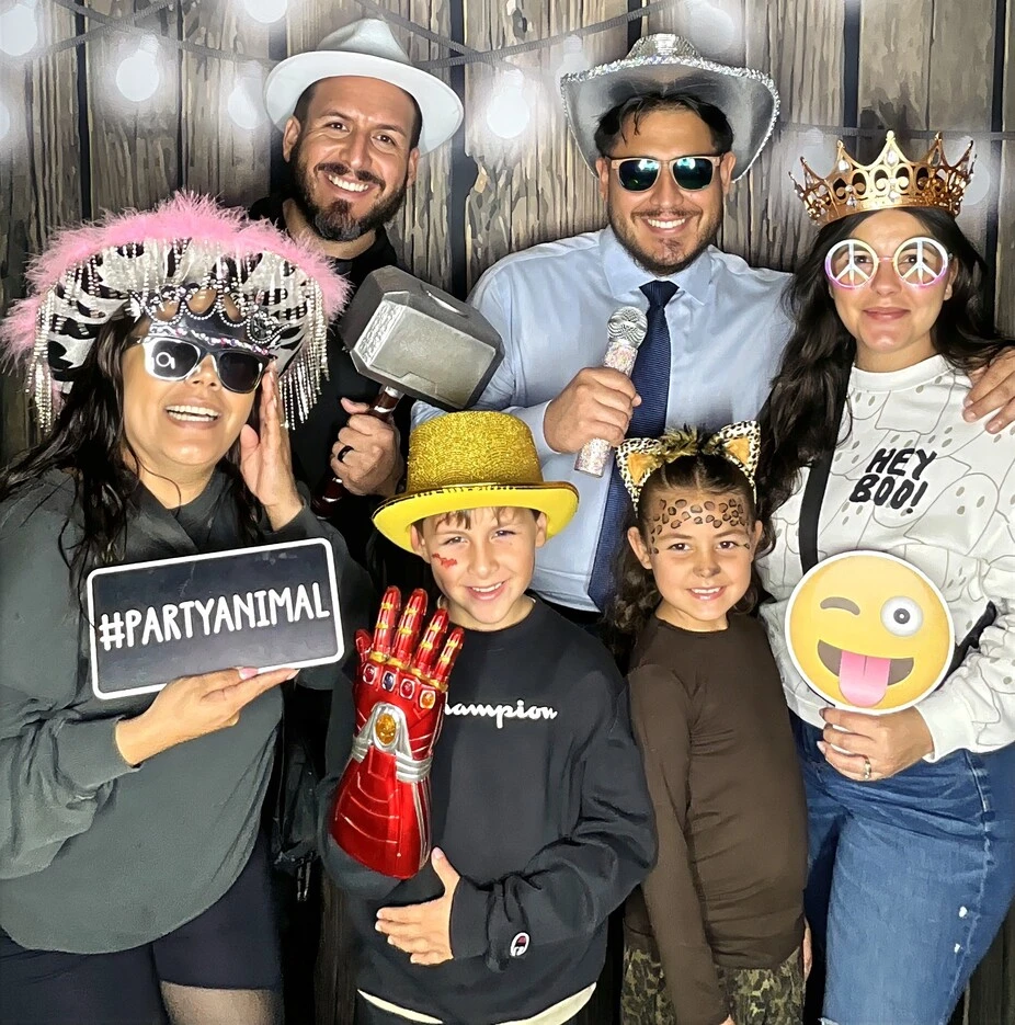 A family poses in party costumes at a Halloween costume party.