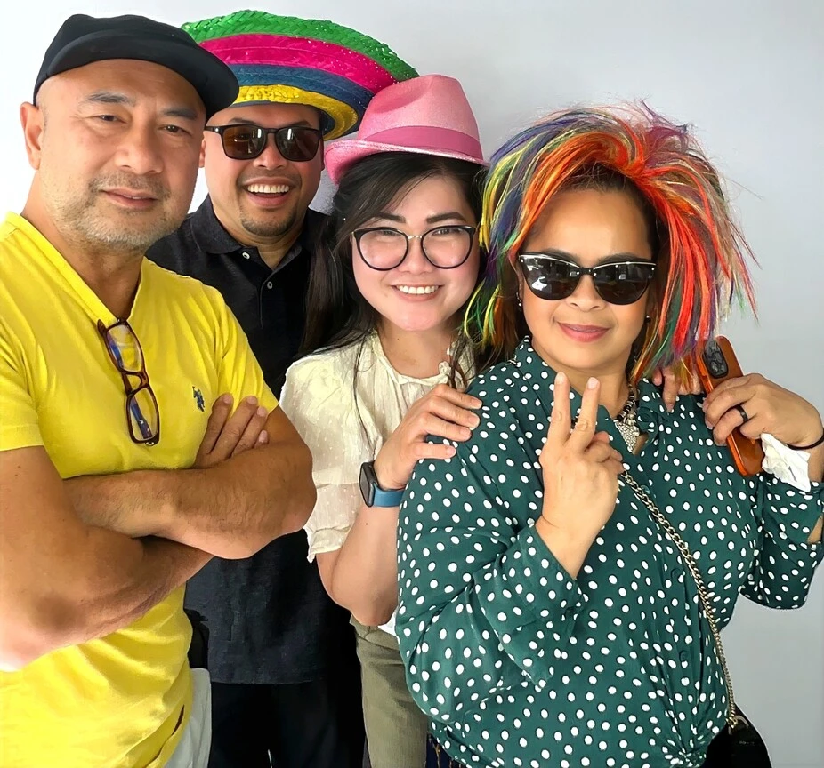 A family poses with playful photo booth props at a family celebration.