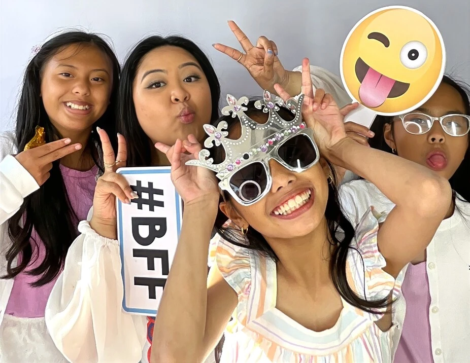 Guests pose with playful photo booth props at a graduation celebration.