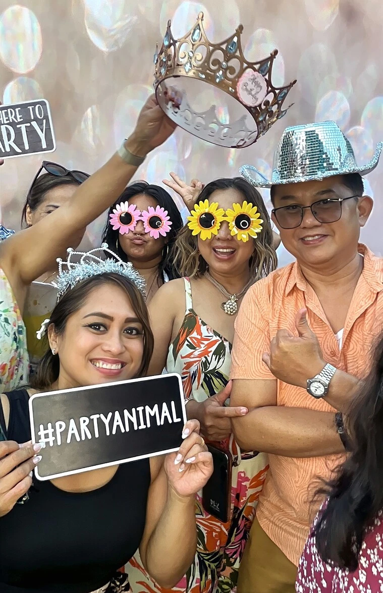 A family poses at a tropical-themed party.