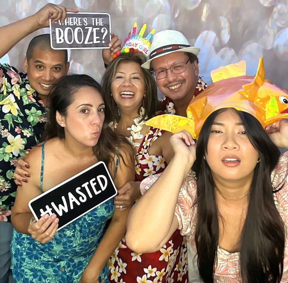 Party guests pose at a tropical-themed party.