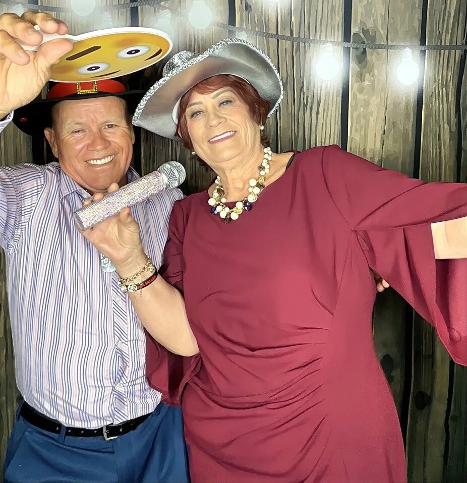 A couple poses with playful photo booth props at a Los Angeles celebration.