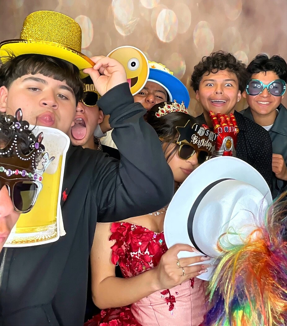 Friends pose with playful photo booth props at a Los Angeles celebration.
