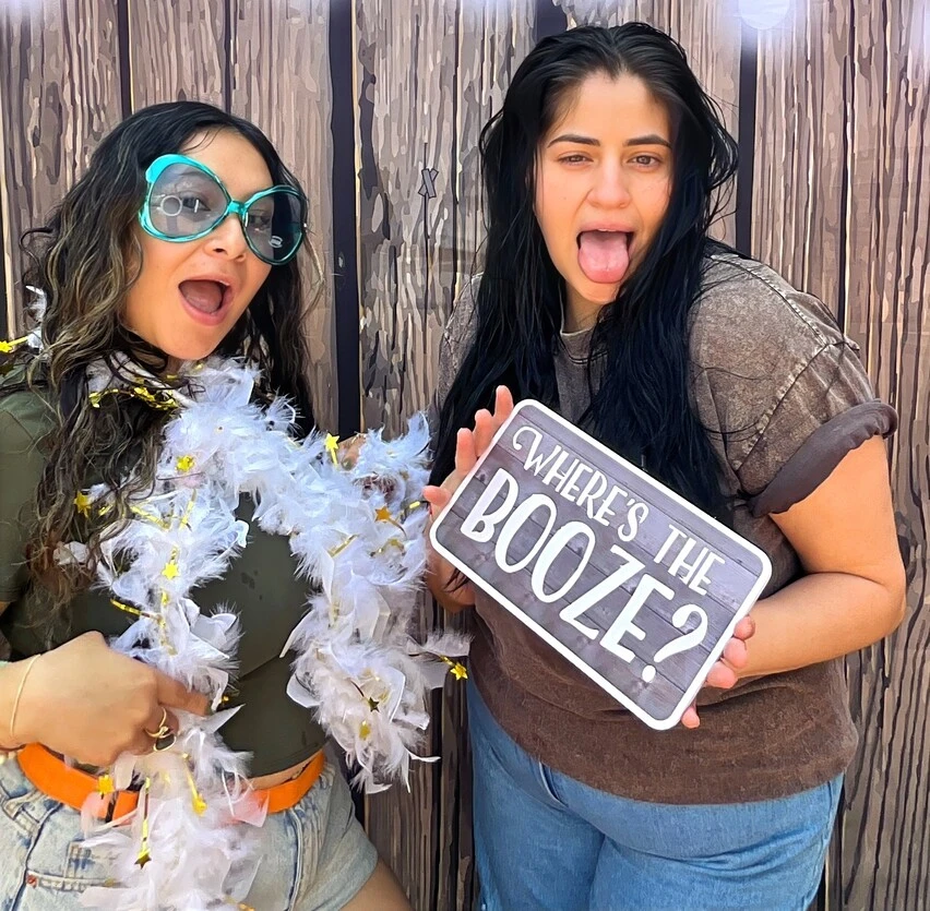 Guests pose with playful photo booth props at a Los Angeles celebration.