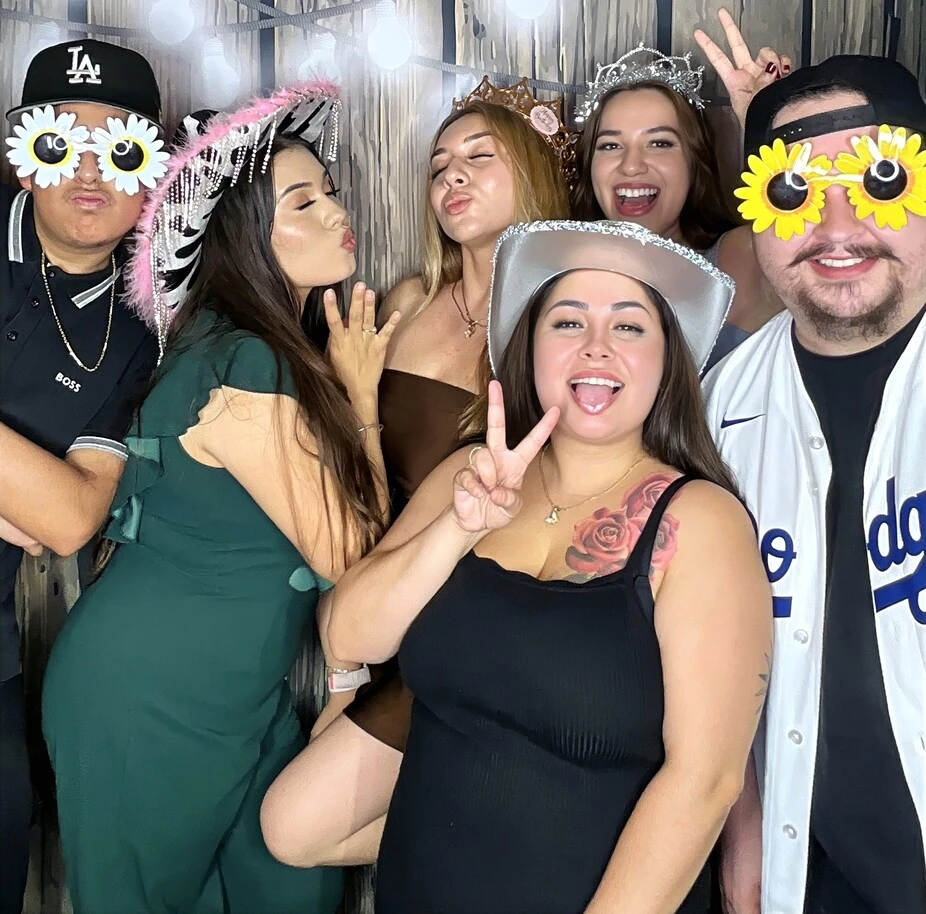 A group of guests poses at a quinceañera celebration.