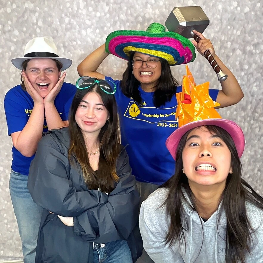 Coworkers pose with playful photo booth props at a team event.