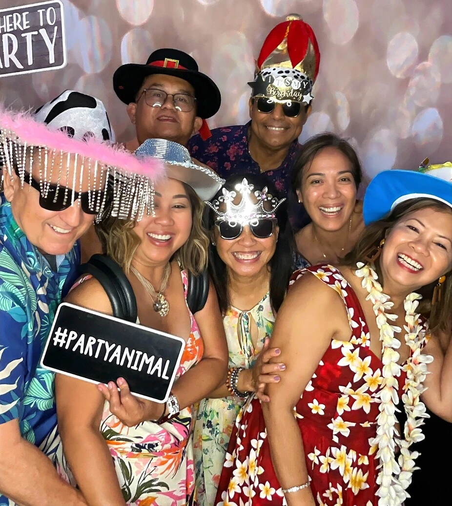 A group of guests poses at a tropical-themed party.