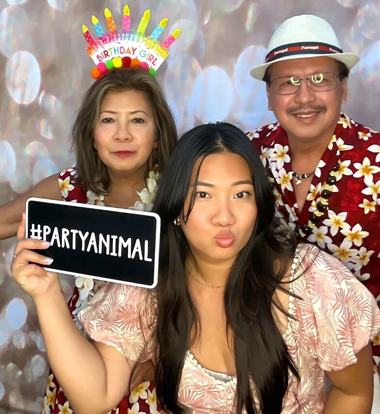 A family poses at a tropical-themed party.