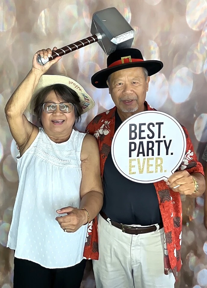 A family poses with playful photo booth props at a family celebration.