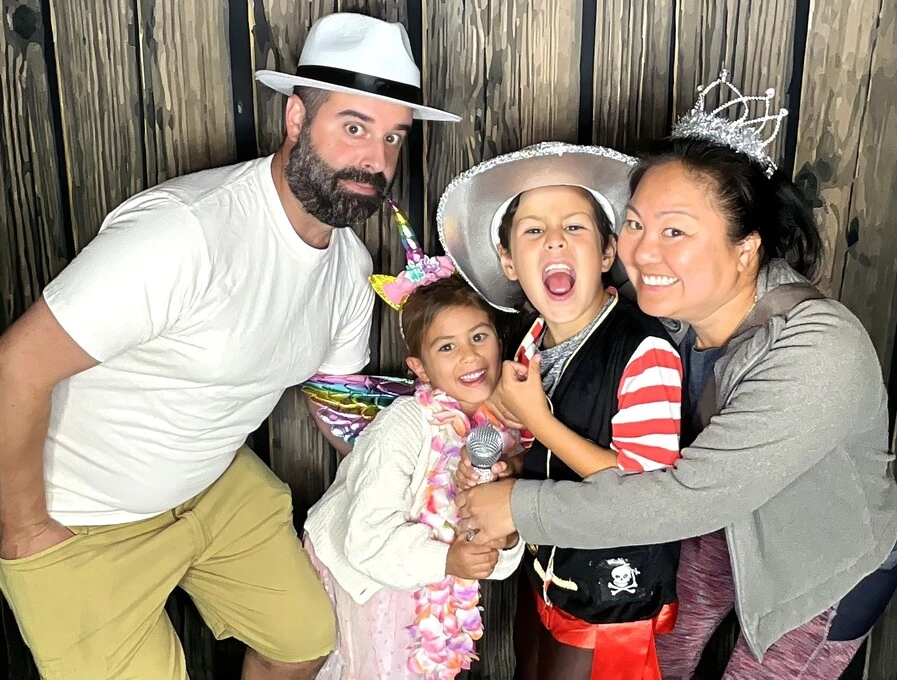 Children pose in party costumes at a Halloween costume party.