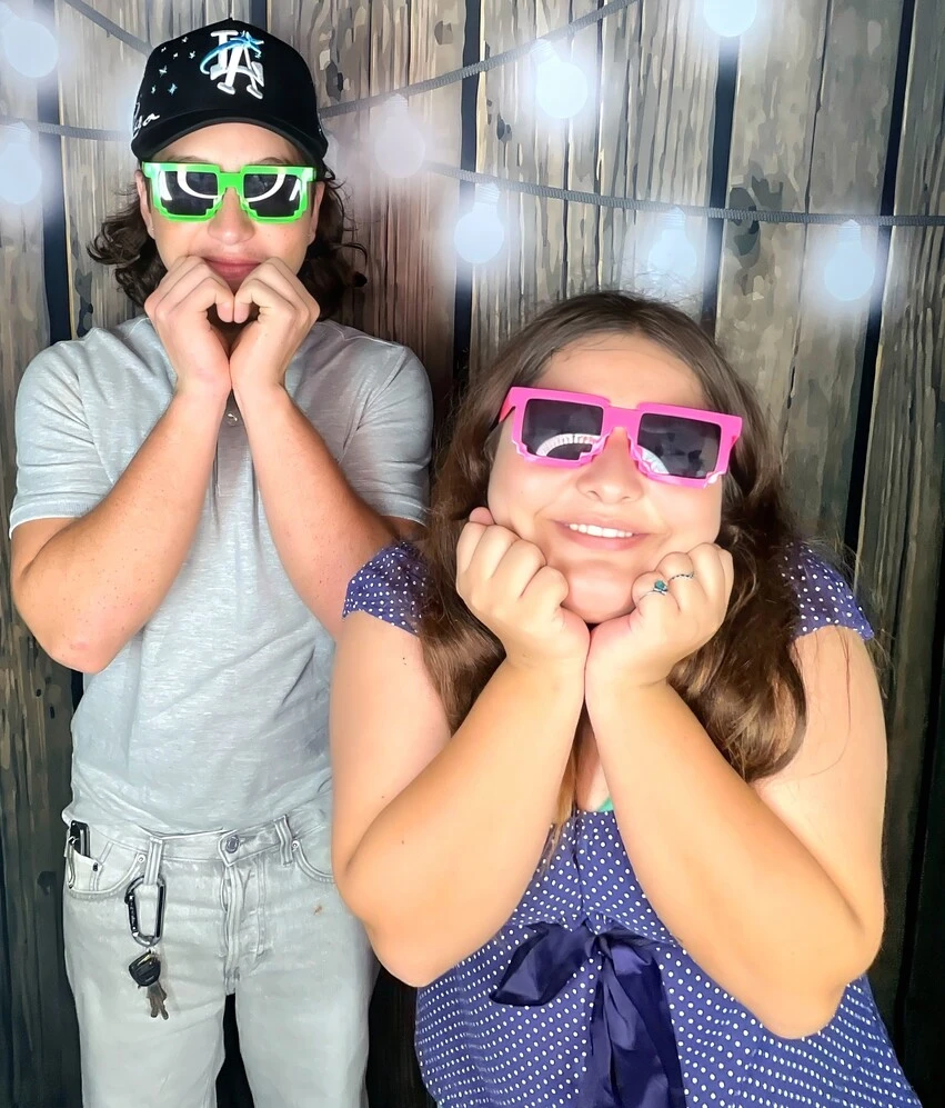 Children pose with playful photo booth props at a Los Angeles celebration.