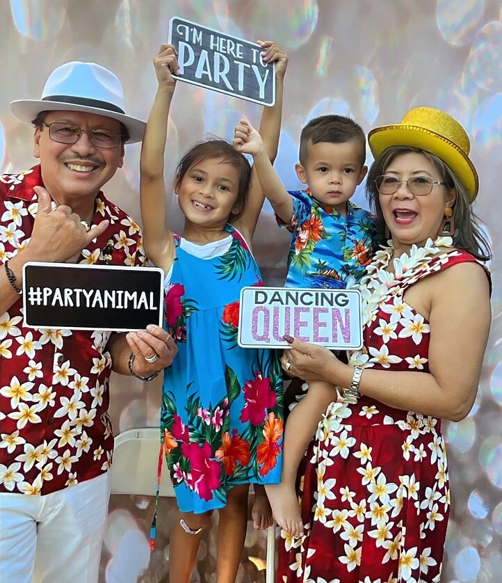 A family poses at a tropical-themed party.
