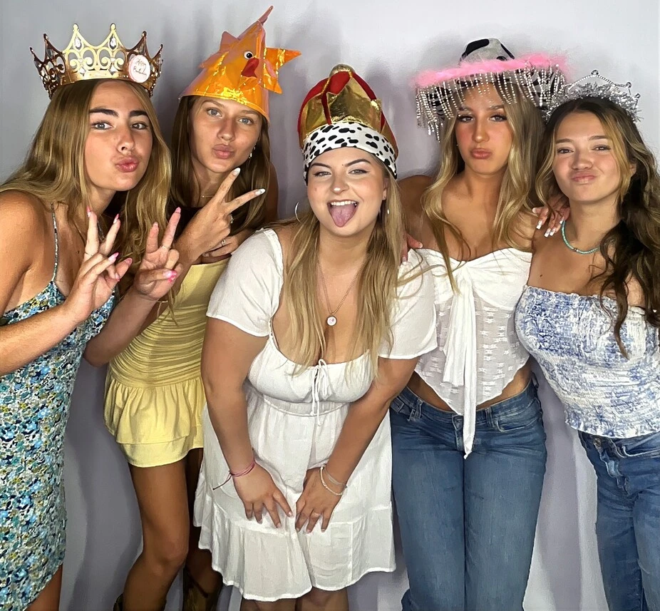 Friends pose with playful photo booth props at a Los Angeles celebration.