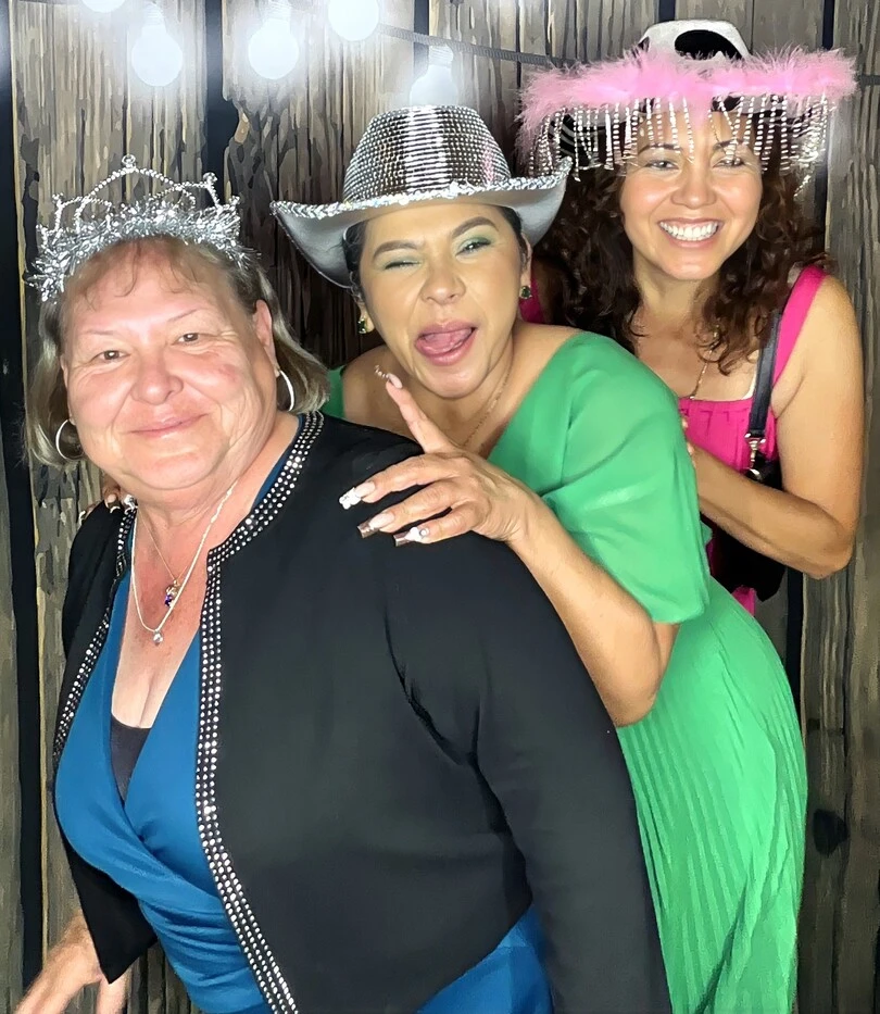 Guests pose with playful photo booth props at a quinceañera celebration.