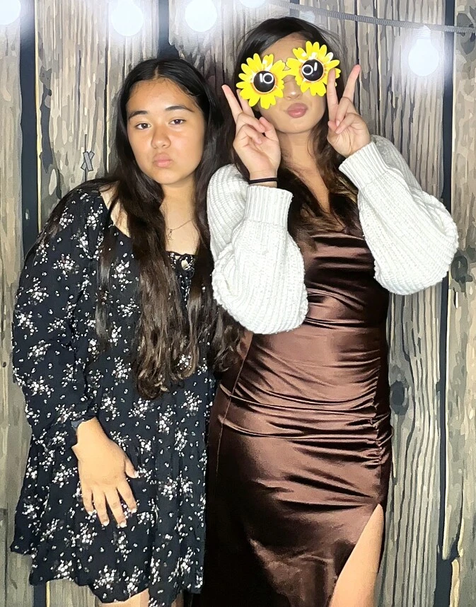 Guests pose with playful photo booth props at a quinceañera celebration.