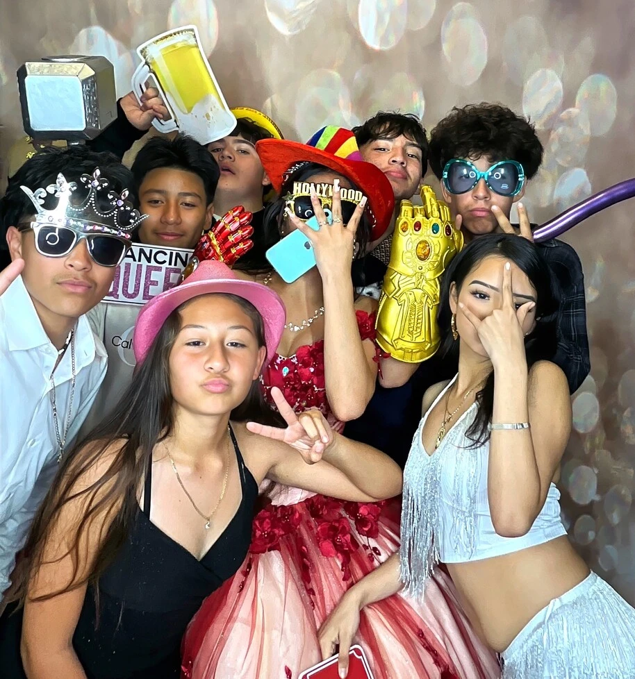 A group of guests poses at a quinceañera celebration.