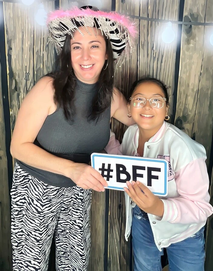 Teen friends pose with playful photo booth props at a Los Angeles celebration.
