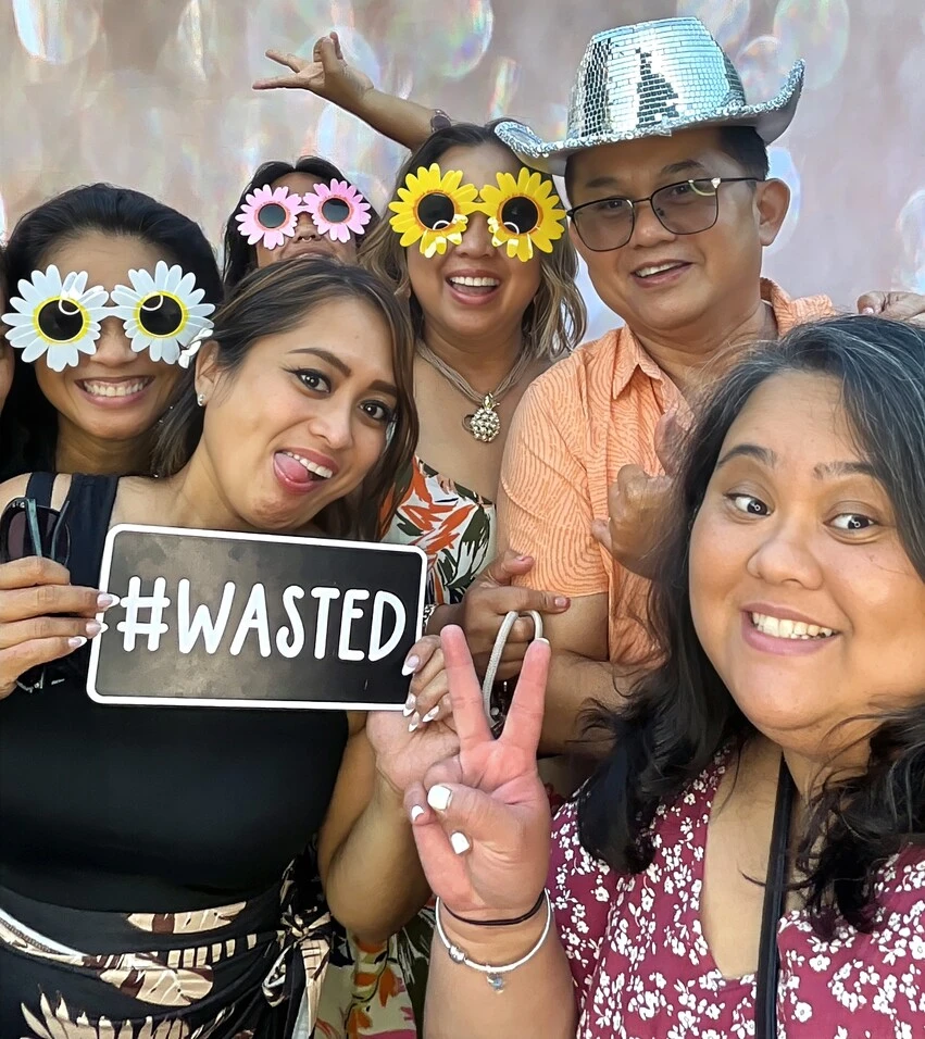 Friends pose at a tropical-themed party.