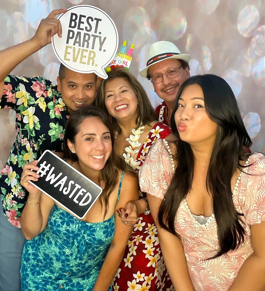 A family poses at a tropical-themed party.