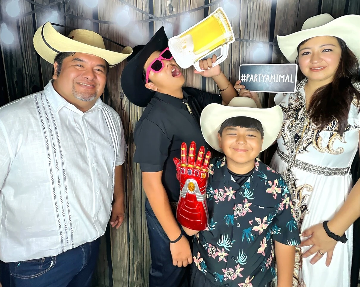 A family poses at a western-themed party.