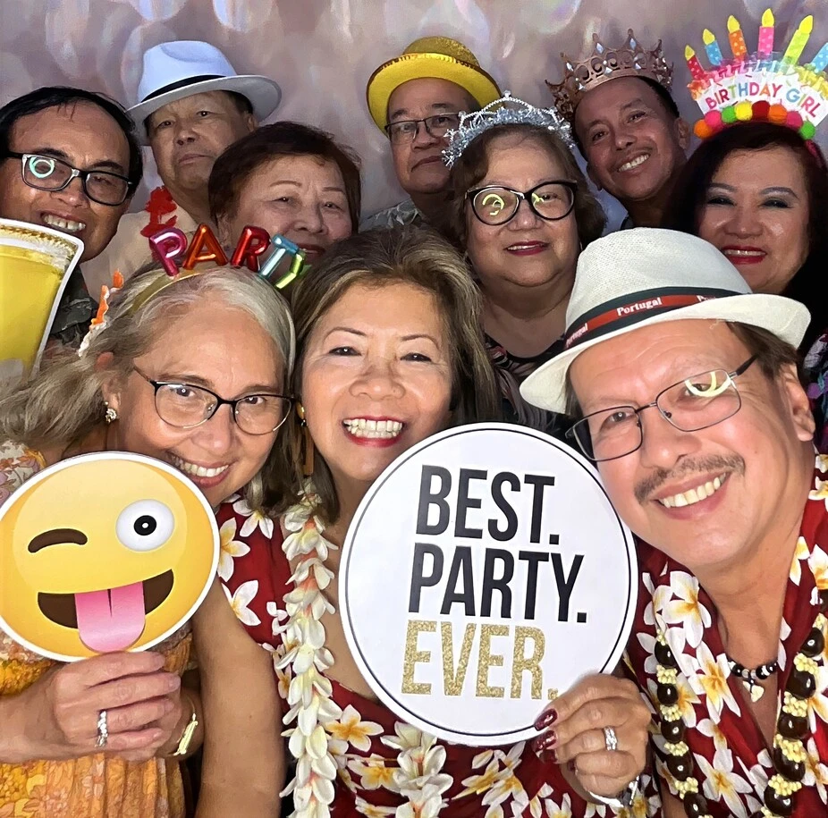 Friends pose at a tropical-themed party.