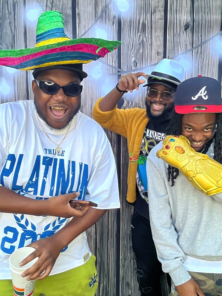 A group of guests poses with playful photo booth props at a Los Angeles celebration.