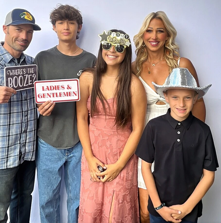 Guests pose with playful photo booth props at a Sweet 16 celebration.