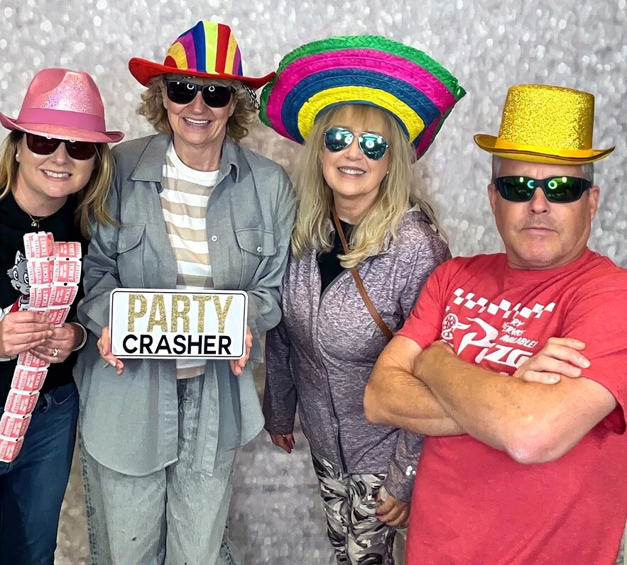 A family poses with playful photo booth props at a family celebration.